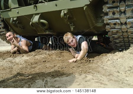 Tyumen, Russia - June 11, 2016: Race of Heroes project on the ground of the highest military and engineering school. Racers move under tank. Caterpillar stage
