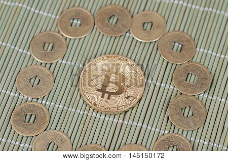 Gold-plated Bitcoin on a wooden tablecloth. Selective focus.