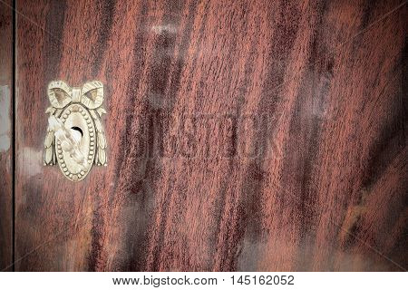 Vintage keyhole with key on vintage wooden cabinet