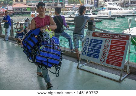 Kota Kinabalu,Sabah-Aug 30,2016:Tourist guide of Jesselton Point Terminal preparing distribute tourist with the life jacket before heading to the islands in Tunku Abdul Rahman Marine Park nearby.
