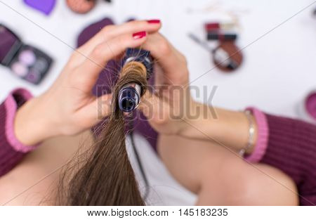 Woman Using Curling Iron On Her Hair