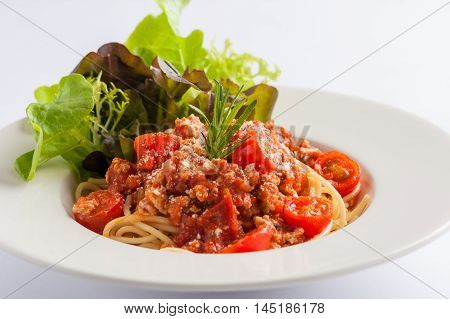 Italian style pasta red sauce with tomato and minced pork garnished with vegetables