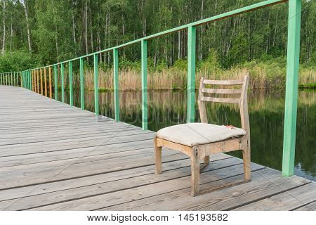 Wooden chair on the pier at Alabuga lake