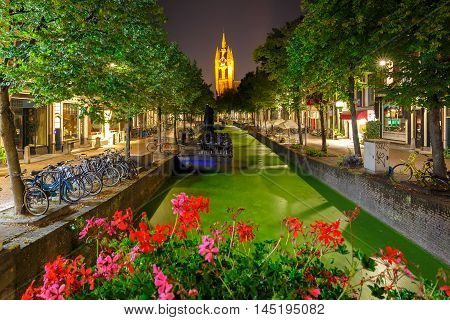 Oude Delft canal and leaning tower of Gothic Protestant Oude Kerk church at night, Delft, Holland, Netherlands