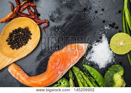 Fresh Raw Salmon Filet With Spicy Herbs On Black Plate