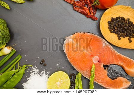 Fresh Raw Salmon Filet With Spicy Herbs On Black Plate