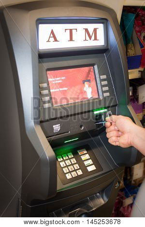ATM Man using ATM cash machine in the store.