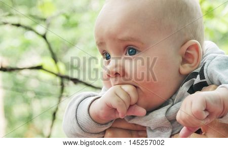 happy young baby child sittng on grass on beautiful summer day in park