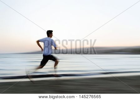 Man jogging on the beach with motion blur