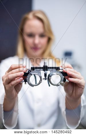 Close-up of female optometrist holding messbrille in ophthalmology clinic