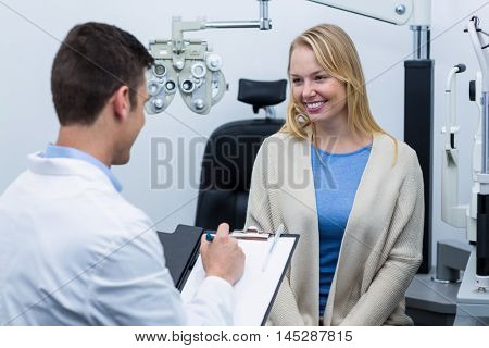 Optometrist consulting female patient in ophthalmology clinic
