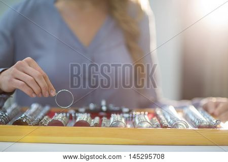 Woman arranging messbrille in tool box at optical store