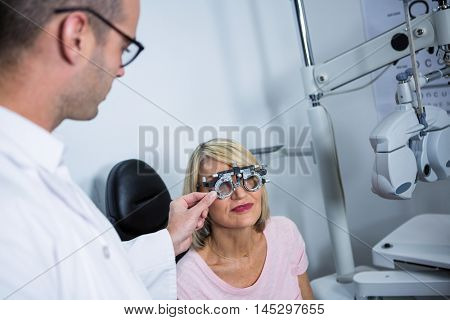 Optometrist examining female patient with messbrille in ophthalmology clinic