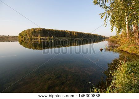 Calm clear lake in the woods by the day