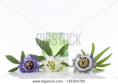 Passion flower with aromatherapy essential oil blue glass bottler isolated over white background.