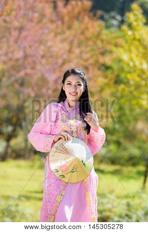 Beautiful vietnamese girl in traditional dress (ao dai) in a park