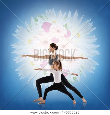 Woman and her daughter doing yoga exercise isolated over white background