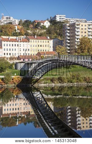 European pedestrian bridge reflected in the river in the day