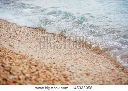 pebble stones by the sea. Silky waves of blue sea