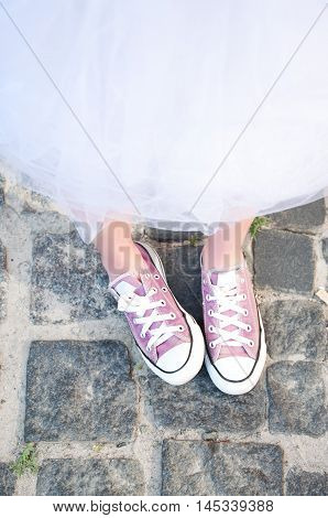 Young adult girl in purple keds and fluffy skirt. Teenager fashion.