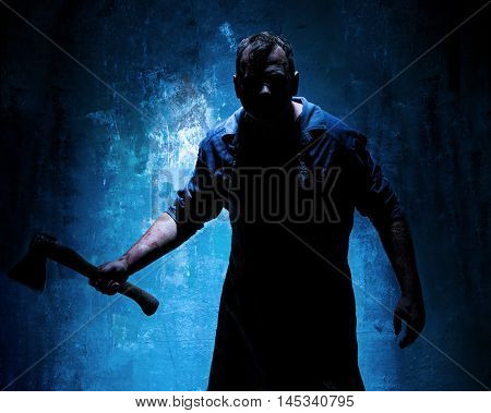 Bloody Halloween theme: crazy killer as bloody butcher with an ax on dark blue background