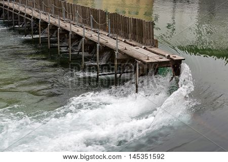 Lucerne Switzerland - May 11 2016: Needle Dam in the river Reuss. Weir was designed to use of thin wooden needles that can be added or removed by hand to maintain the level of water in Lake Lucerne. The Needle Dam is located in the old town of Lucerne. Lu