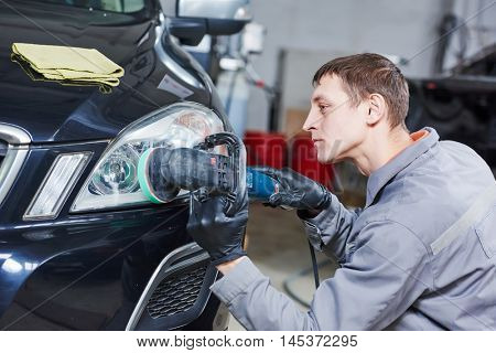 auto mechanic buffing and polishing car headlight