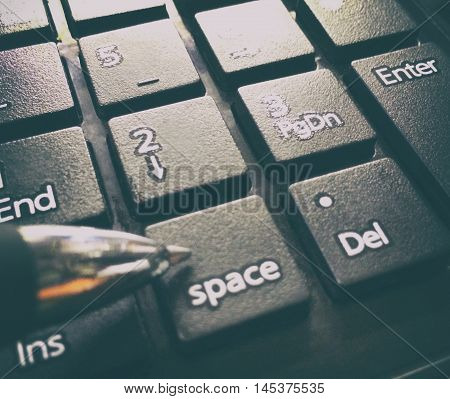 Black Number Key pad with pen pointing at space.