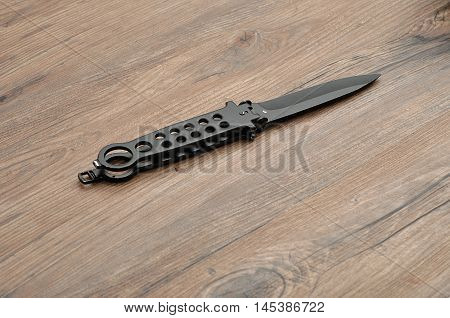 Steel butterfly knife (balisong) isolated on a wooden background