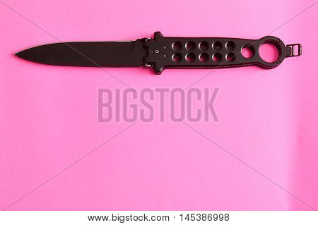 Steel butterfly knife (balisong) displayed on a colorful background