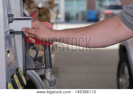 Male using credit card at the gas pump, fuel prices going up and down.