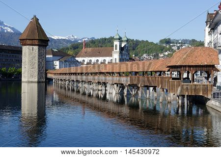 LUCERNE SWITZERLAND - MAY 05 2016: View towards Chapel Bridge (Kapellbruecke) together with the octagonal tall tower (Wasserturm) it is one of the Lucerne's most famous tourists attraction