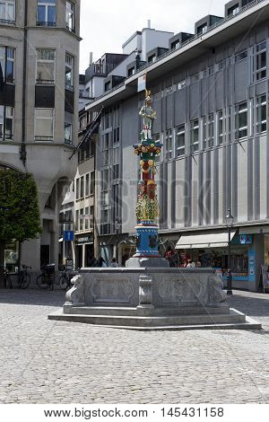 LUCERNE SWITZERLAND - MAY 04 2016: Fritschi Fountain in Gothic style with its colorful pillar is located in old town. A variety of fountains is a great tourist attraction in the city