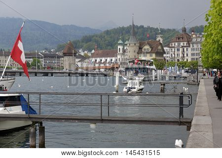 Lucerne Switzerland - May 02 2016: The city as seen from the Lake Lucerne. The octagonal stone tower which is one of the most recognizable landmarks in the city that can be seen from a far distance. Panorama of the city shows unique character and diversit