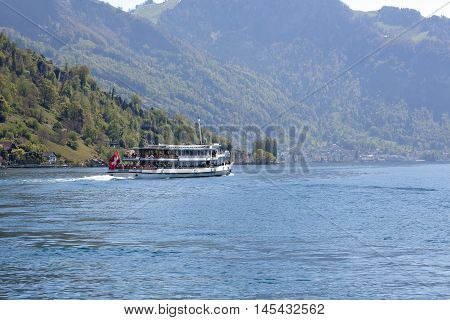 Weggis Switzerland - May 05 2016: Swiss Motor Cruise Ship Waldstatter sailed from the ferry terminal in Weggis and is seen on Lake Lucerne. There are several people in a far distance can be seen on board.