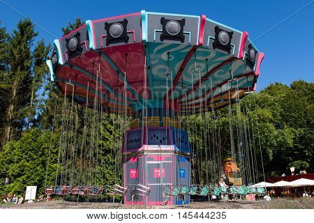 Biddinghuizen, The Netherlands - August 24, 2016: High speed carousel with park visitors during a ride at Walibi theme park.