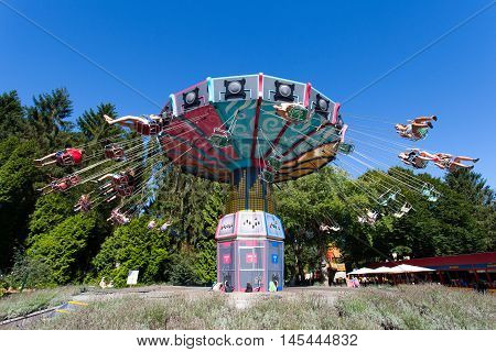 Biddinghuizen, The Netherlands - August 24, 2016: High speed carousel with park visitors during a ride at Walibi theme park.