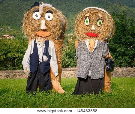 Pretty farmer Puppets(straw dolls) made out of Hay Bale with typical peasant clothes in europe autumn.