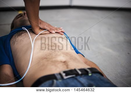 girl making heart massage to an unconscious man