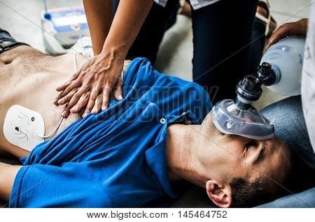 operators assisting an unconscious man with cardiopulmonary resuscitation