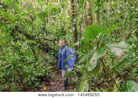 Young Caucasian Woman With Rain Coat Traveling Along Rainforest Deep In The Cuyabeno Jungle South America