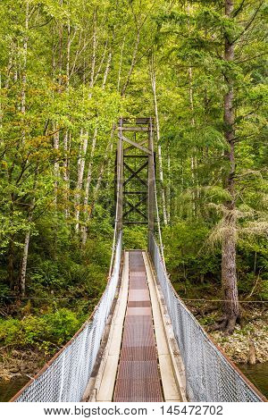 Photo of wooden suspention bridge in countryside.