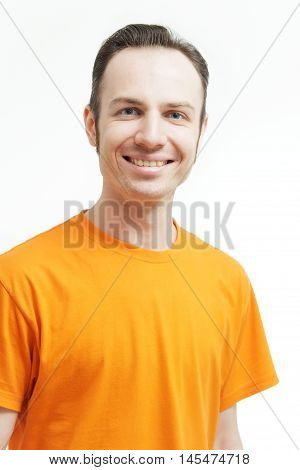 Close-up portrait of smiling guy . Over white background. Smiling guy in an orange T-shirt. Age defying skin care anti aging flawless spa treatment beautiful man smiles