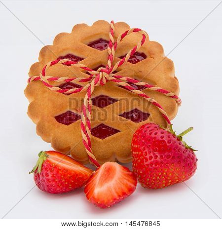 stack of cookies with jam and strawberries on white background