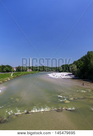 The Isar river in Munich with many unidentified people on a sunny day taking a sunbath