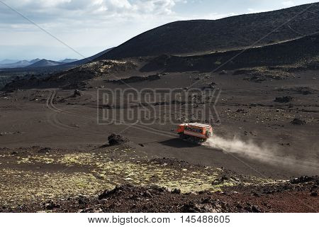 KAMCHATKA PENINSULA RUSSIA - JUNE 24 2016: Russian expedition truck KamAZ (6-wheel drive) transportation tourists on mountain road in the vicinity of the volcano. Eurasia Far East Russia Kamchatsky Region Klyuchevskaya Group of Volcanoes.