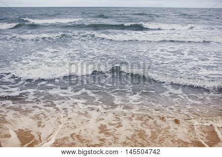 the view from the shore of the sea in cloudy weather