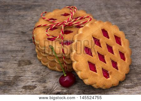Biscuits with cherries. Gray wood floor background.
