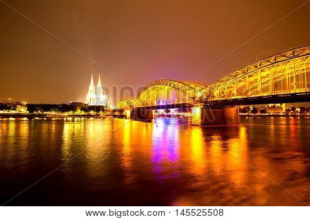 Cologne in Germany at night with the river Rhein and the famous cathedral in the background.