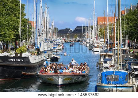 Copenhagen Denmark - August 15 2016: View on canal with tourist boat beetwen Overgaden Oven Vandet street and Overgaden Neden Vandet street from bridge Sankt Anne Gade in Copenhagen Denmark